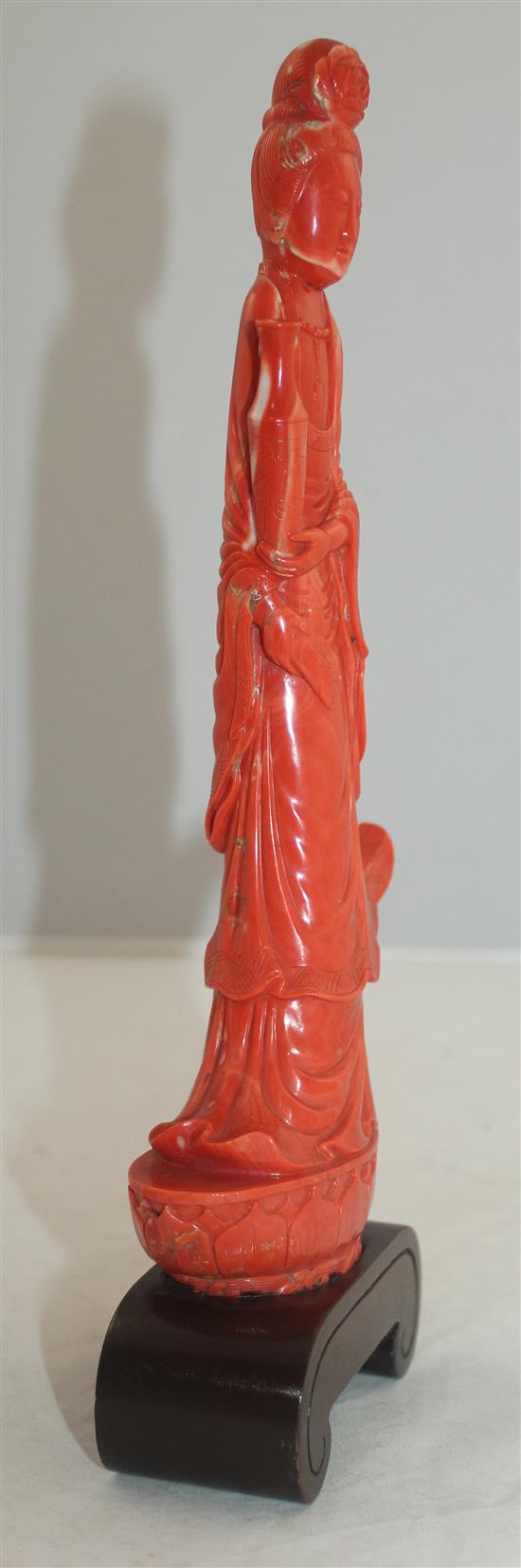 A large Chinese coral figure of Guanyin, 27.7cm incl. wood stand